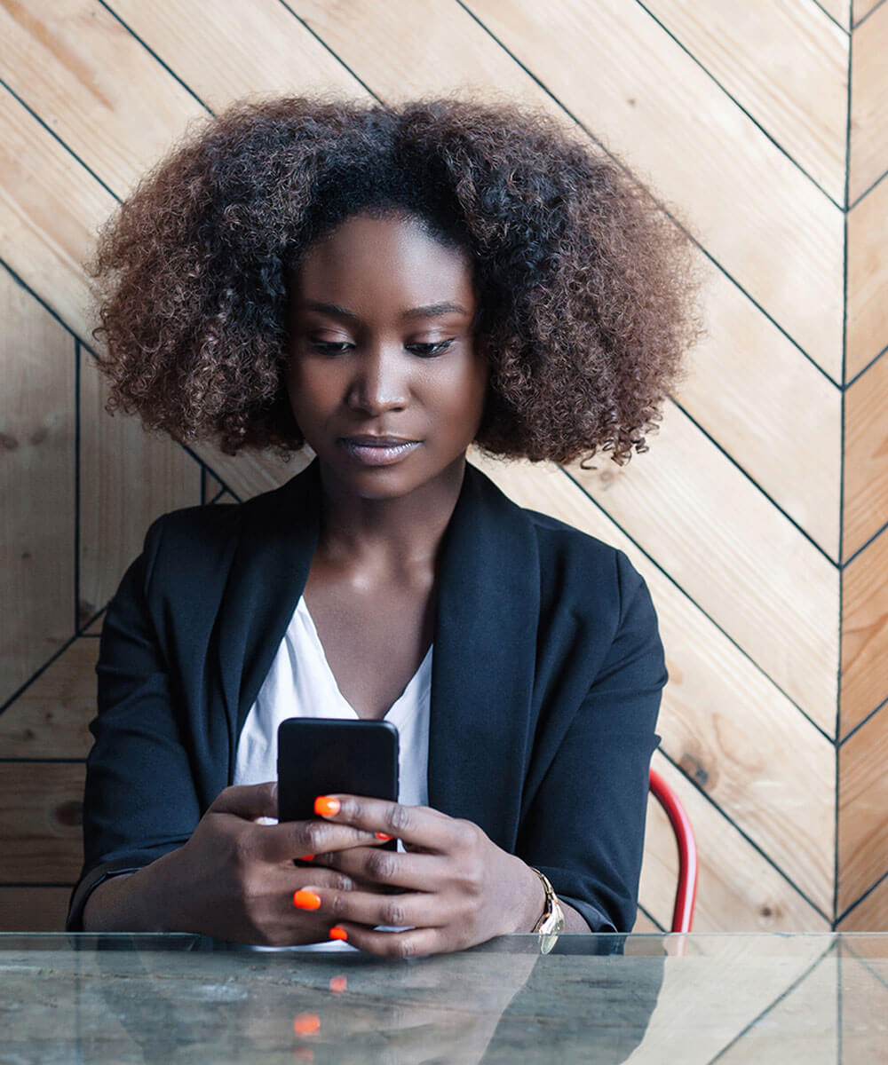 Person sitting at table looking at phone